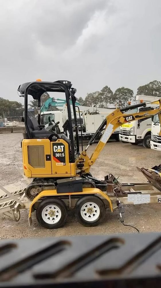 Mini excavator loaded on a trailer, ready for transport